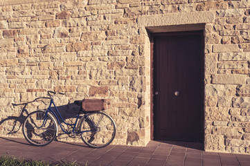 Fototapeta na wymiar Vintage bicycle and old suitcase in a stone wall
