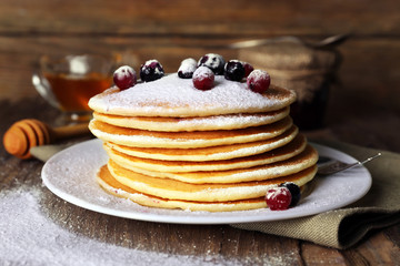 Stack of delicious pancakes with powdered sugar and berries