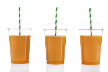 Orange juice in fast food closed cups with tubes isolated