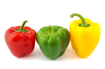 Close up of green, red and yellow fresh peppers on white