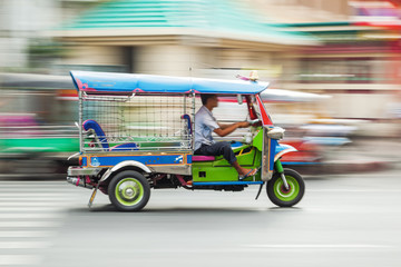Naklejka premium tradycyjny tuk tuk w Bangkoku w zamazanym ruchu