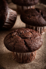 Chocolate cake muffins on a table. Dark lighting