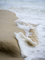 Fototapeta na wymiar Waves crashing on the sand