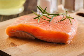 Raw salmon filet on wooden cutting board