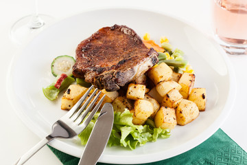 Fried pork with potatoes and vegetables salad