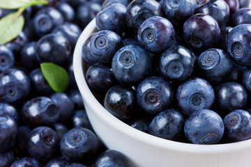 blueberries in the white bowl on a wood rustic background