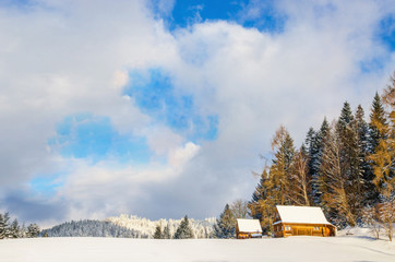 Meadow without trails and mountain hut in winter scenery