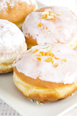 donuts with frosting and powdered sugar on a platter