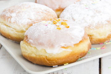 donuts with frosting and powdered sugar on a platter