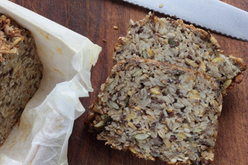Piece of whole grain bread on wooden board.