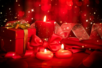 Valentine red heart shaped candles and gift on red silk