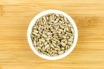 Bowl of sunflower seeds against wooden background