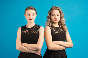 Two women in identical dresses are angry at each other