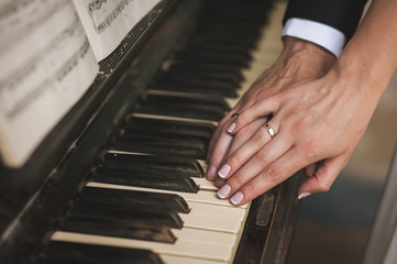 hands with wedding rings on piano