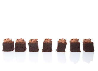 Bite sized chocolate cake with icing on top over white