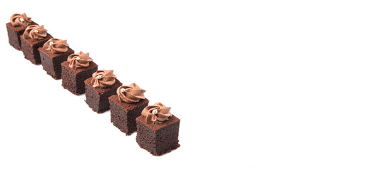 Bite sized chocolate cake with icing on top over white