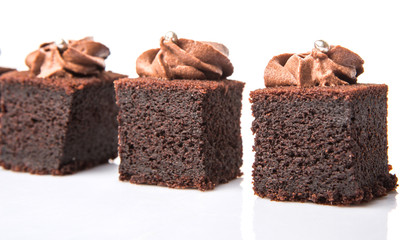 Bite sized chocolate cake with icing on top over white 