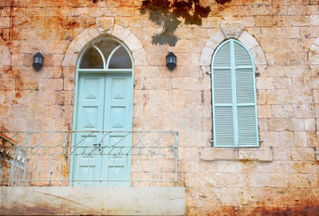 Fototapeta na wymiar old house wall from jerusalem stone with old blue balcony. filte
