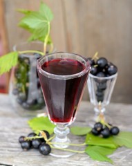 black currant liquor and ripe berries  on  wooden table