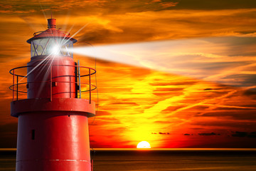 Rode vuurtoren met lichtstraal bij zonsondergang