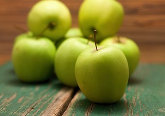 Green apple placed in the fron before other fruit