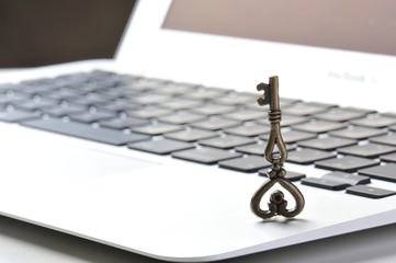 パソコンのキーボードと小さな鍵の写真,個人情報保護のイメージ