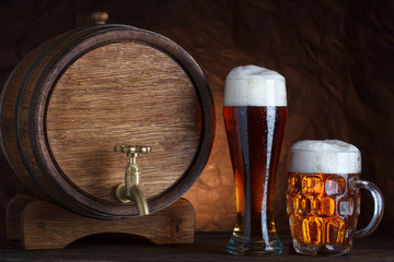 Beer barrel with two beer glasses on wooden table