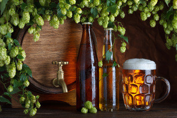 Beer bottles with glass of beer and barrel