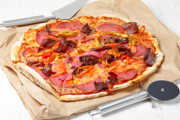 Pizza with ham, salami and chili pepper