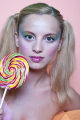 Girl holding a lolly pop, in pink background