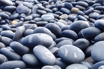 Fototapeta na wymiar The hard pebbles closeup on the beach