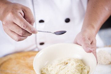 Chef cooking Noodle with seasoning sauce