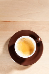 Eine Tasse Kaffee steht auf einem Holztisch