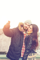 Attractive couple doing selfie outdoors.