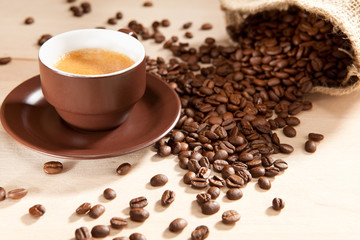 Eine Tasse Kaffee und Bohnen aus dem Jutesack