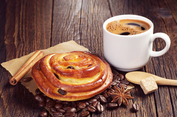 Tasty bun and cup of coffee