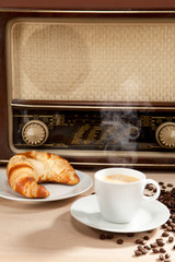 Radiohören beim Frühstückskaffee mit Croissant