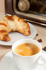 Radiohören beim Frühstückskaffee mit Croissant