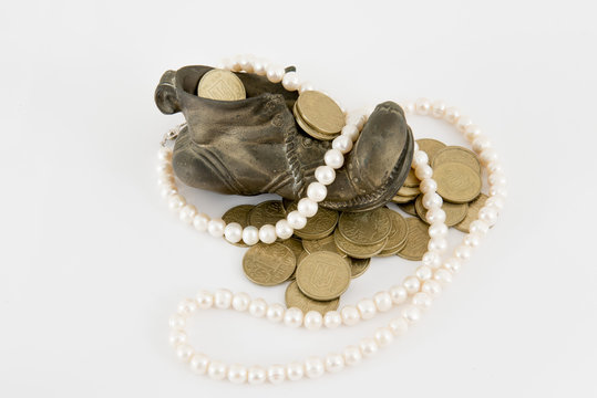 Old bronze shue filled with gold coins and pearls on white