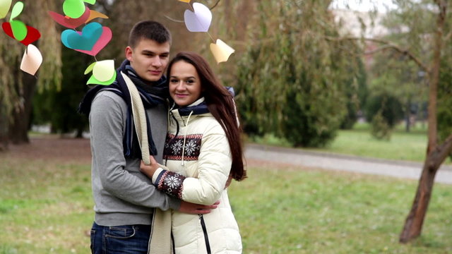 loving couple standing near a multi-colored hearts on Valentine'