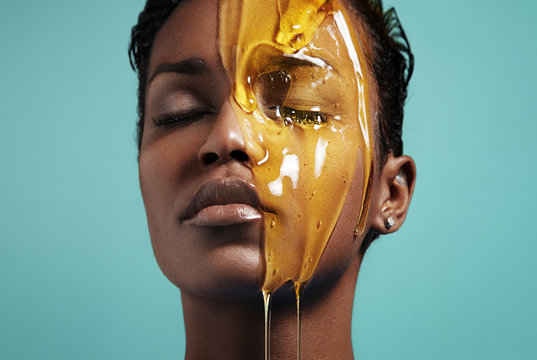 closeup portrait of a black woman with a honey on her face