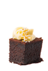 Bite sized chocolate cake with cream cheese toppings over white 