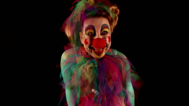 dancing clown with balloons in front of black