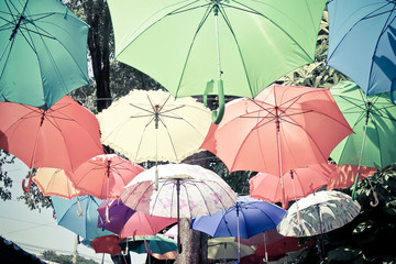 color umbrellas hanging in the air in park