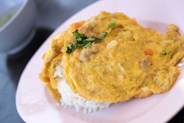 A plate of fried rice with an omelette on top.