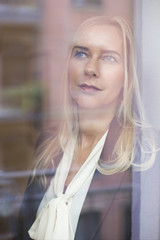 blond woman looking out of  window