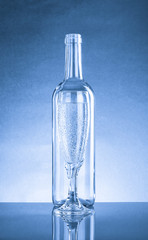 Empty bottle and glass with a pop of transparent glass. Standing