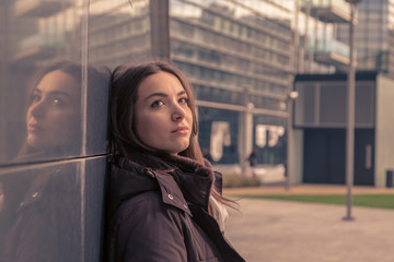 Obraz premium Young beautiful girl posing in the city streets