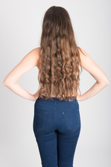 Woman with long hair wearing white t-shirt and blue jeans