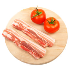 Raw red meat fat bacon and tomato on a wooden board isolation
